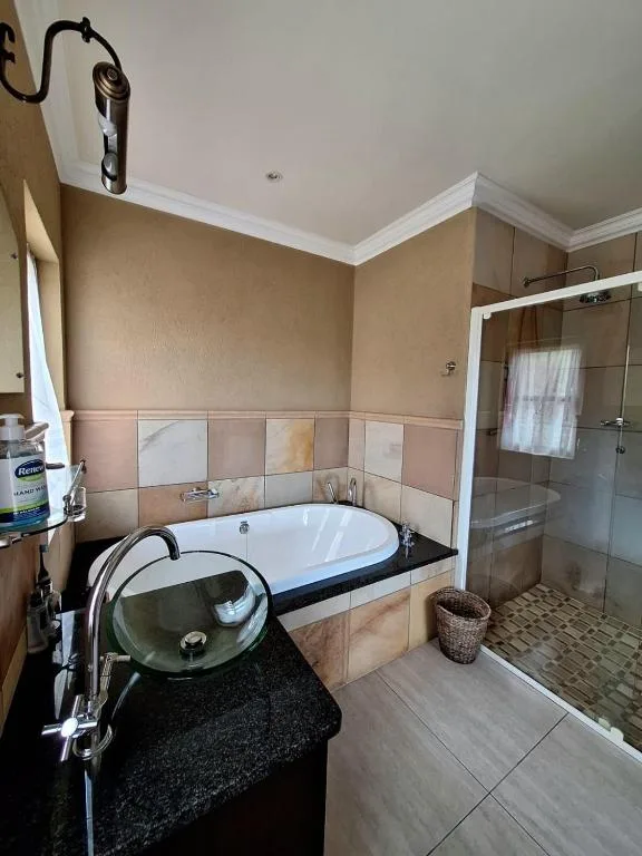 Spacious bathroom with sunken bathtub and modern glass shower enclosure