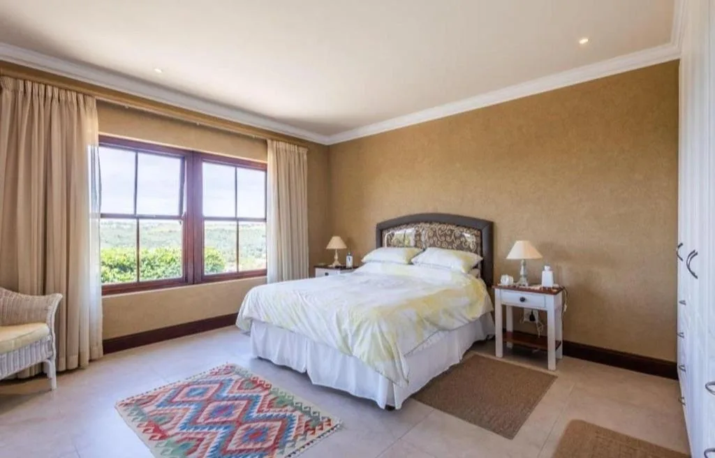 Spacious bedroom with queen bed, mountain views through large windows