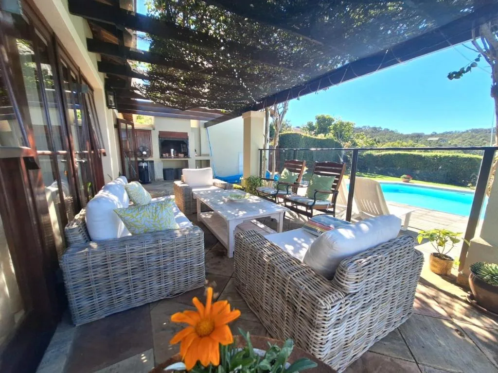 Shaded outdoor seating area with wicker furniture and pool view