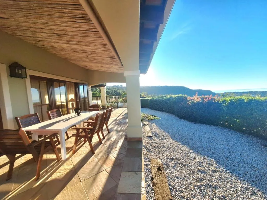 Covered patio with dining table overlooking river and mountains