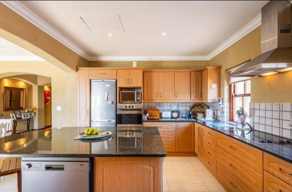 Spacious kitchen with wooden cabinetry, dark countertops, and stainless steel appliances