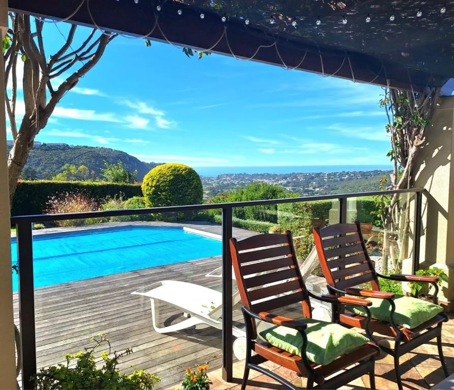 Swimming pool on wooden deck with mountain views and lounging chairs