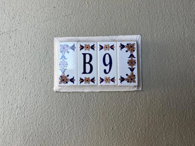 Decorative ceramic house number B9 with blue and brown floral tiles