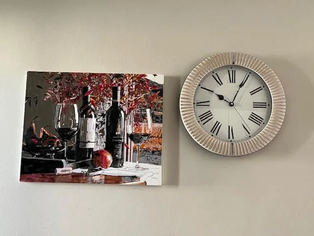 Wall decor with wine artwork and decorative Roman numeral clock