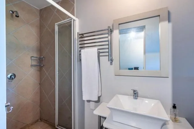 Modern bathroom with shower enclosure, heated towel rail, and white vanity sink