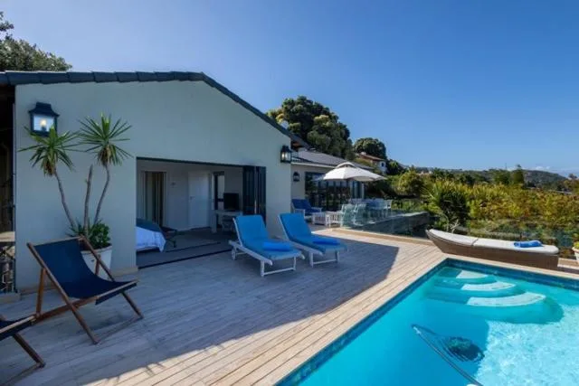 Modern deck with loungers, pool access, and mountain views beyond