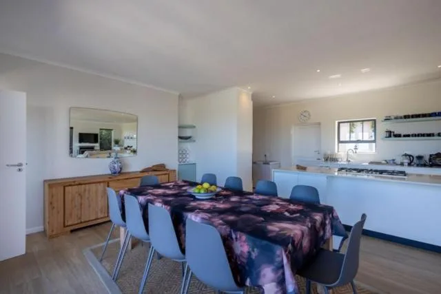 Open-plan dining area with wooden table and blue chairs