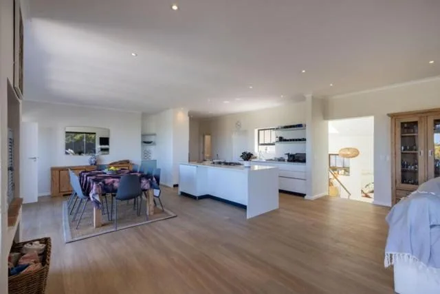 Modern open-plan lounge with dining area and kitchen visible in background