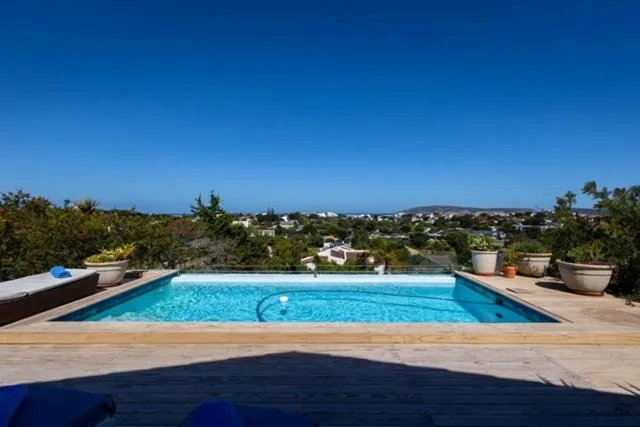 Sparkling blue swimming pool overlooking Plettenberg Bay countryside and hills
