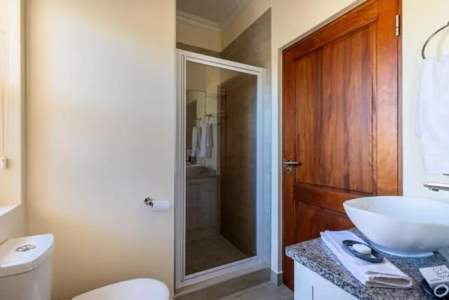 Modern bathroom with shower, toilet, and vanity sink with stone countertop