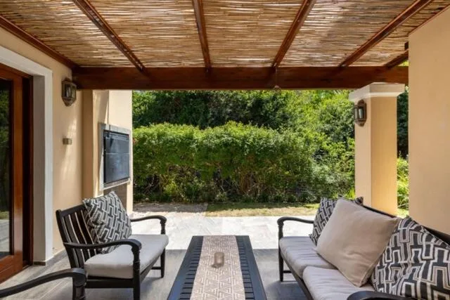 Covered patio with comfortable seating and lush garden views