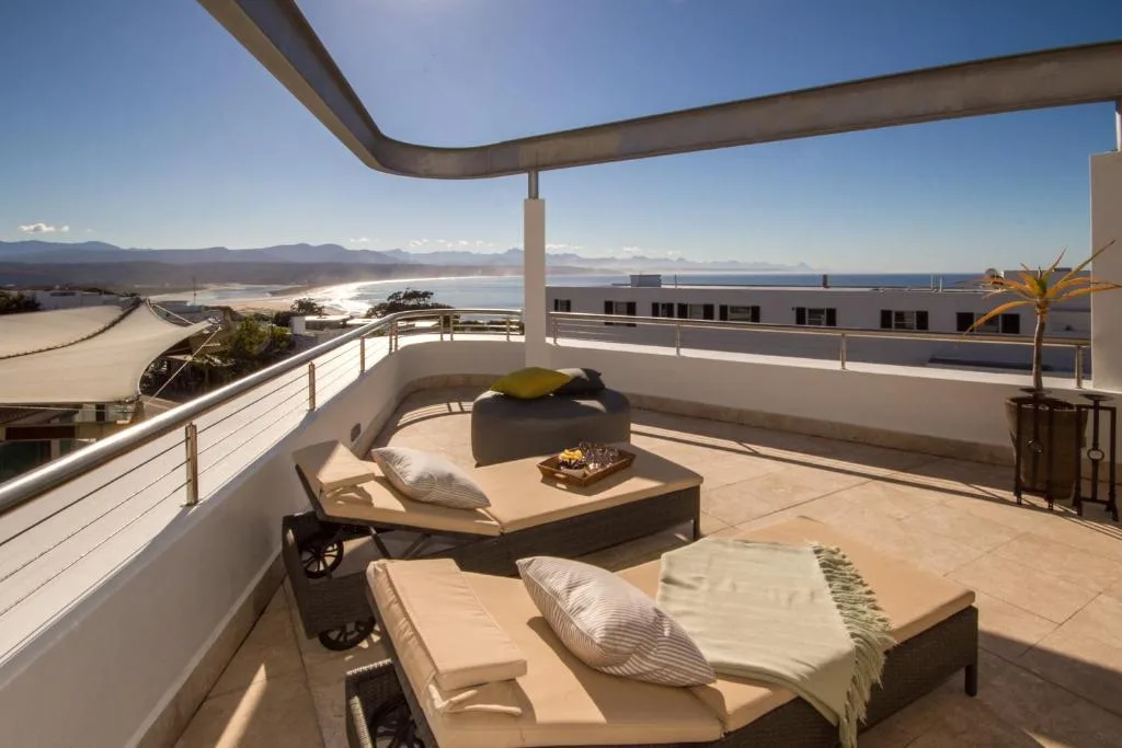 Spacious upper deck with loungers overlooking bay and mountains