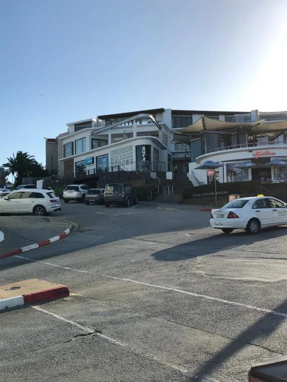 Modern beachfront apartment building with parking area and palm trees