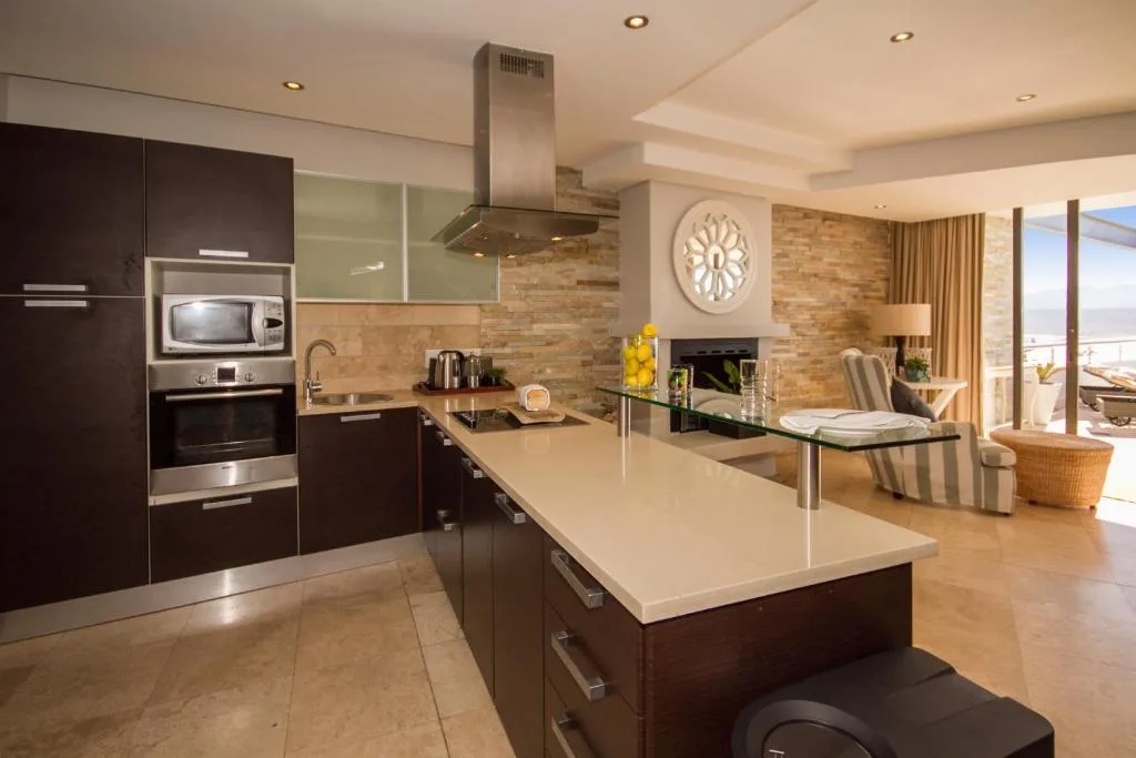 Modern kitchen with dark cabinetry, stainless steel appliances, and white countertops