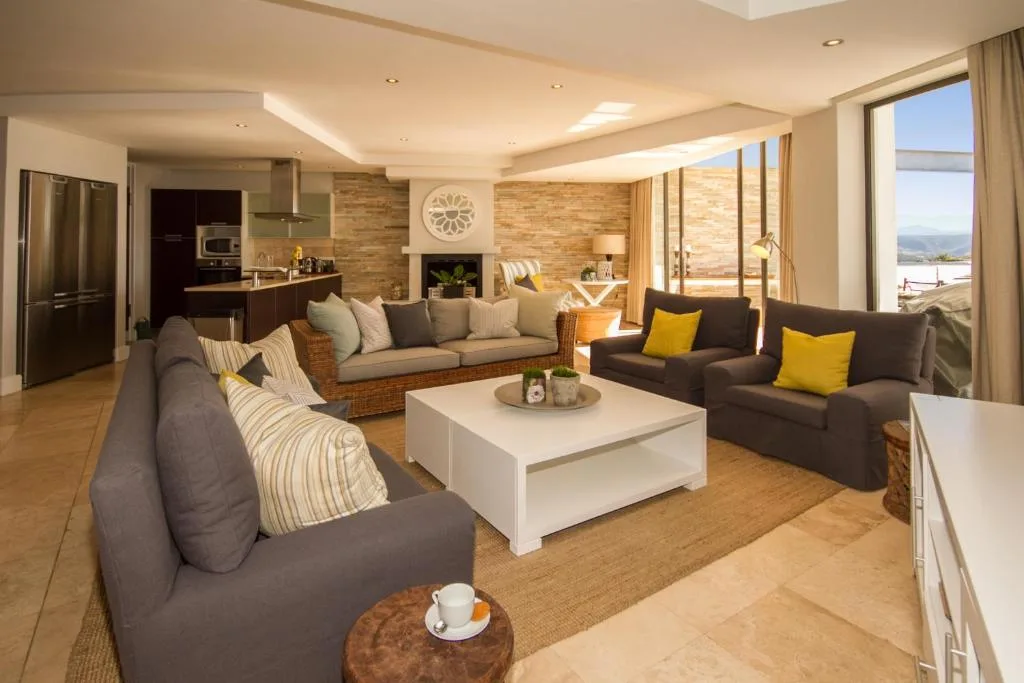 Open-plan lounge with multiple sofas, fireplace, and scenic views