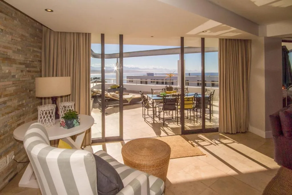 Bright lounge with striped armchair overlooking ocean-view deck