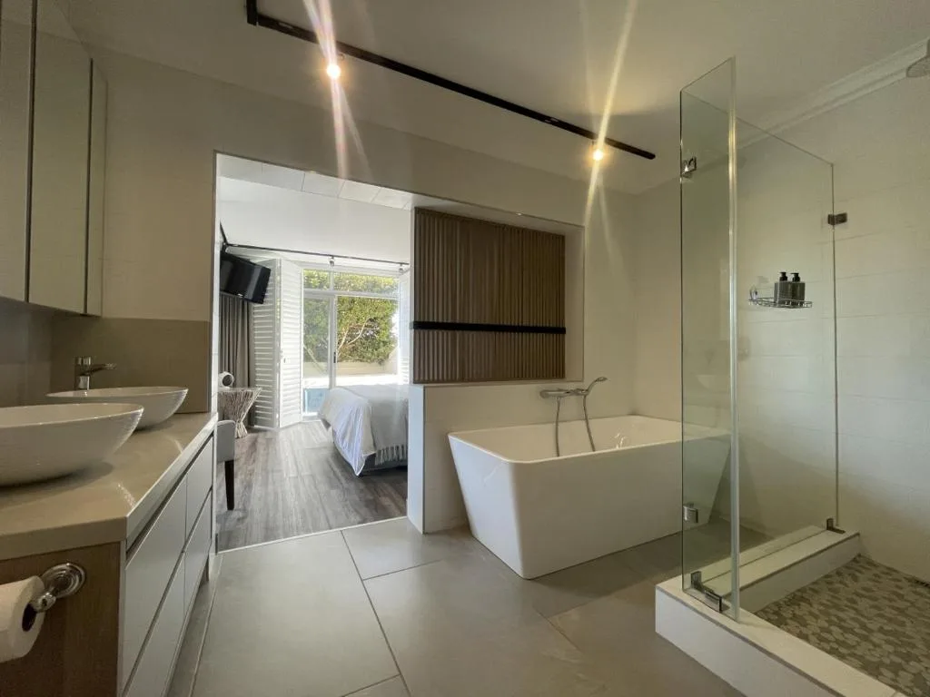 Modern bathroom with freestanding tub, walk-in shower, and dual vanities