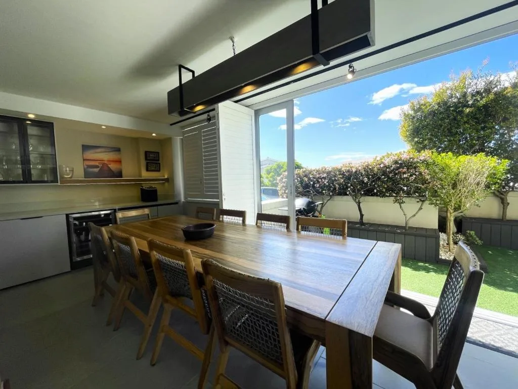 Modern dining table with chairs overlooking garden and lagoon views