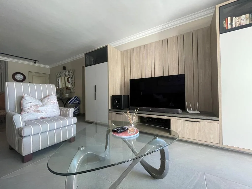 Modern living room with striped armchair and wall-mounted television