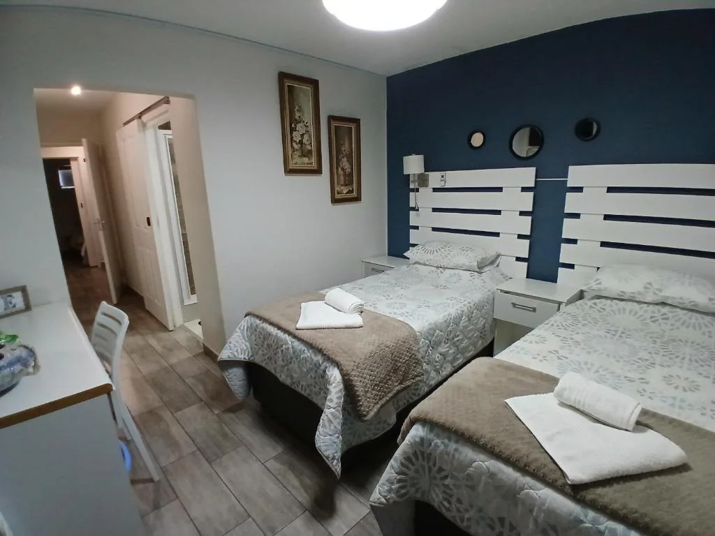 Spacious bedroom with multiple beds and modern white headboards