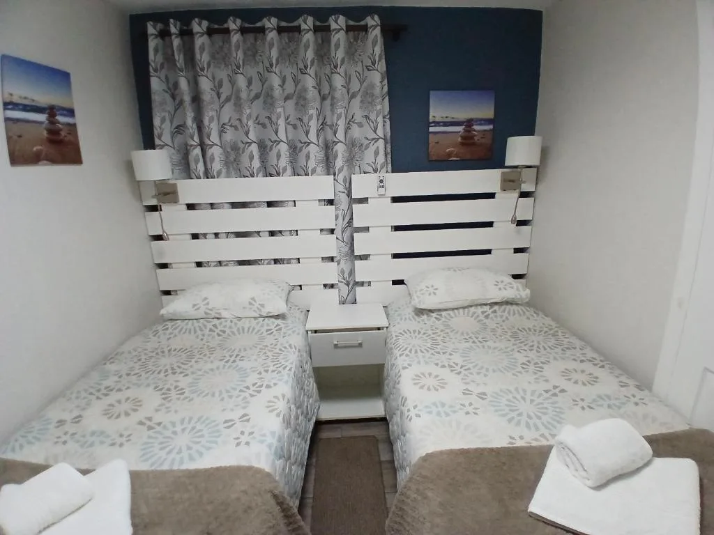 Twin bedroom with white wooden headboards and patterned bedding