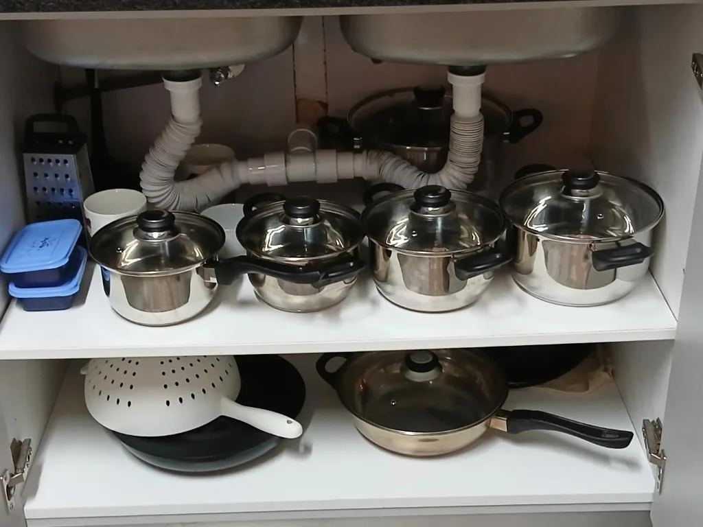 Under-sink kitchen cabinet with cookware collection and storage organization