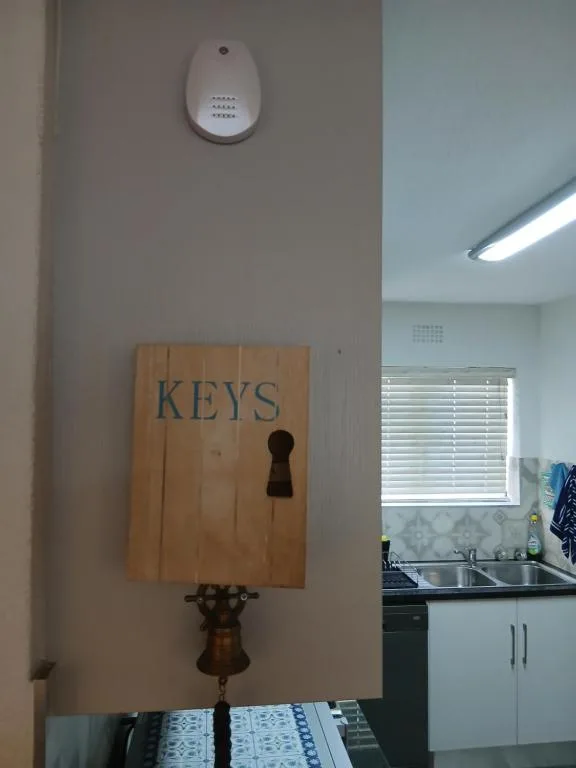 Wooden keys holder mounted on kitchen wall near window