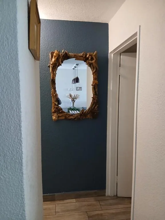 Ornate wooden-framed mirror on dark accent wall in hallway