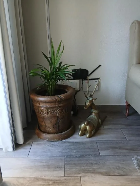 Decorative plant pot and brass animal figurine on tiled floor