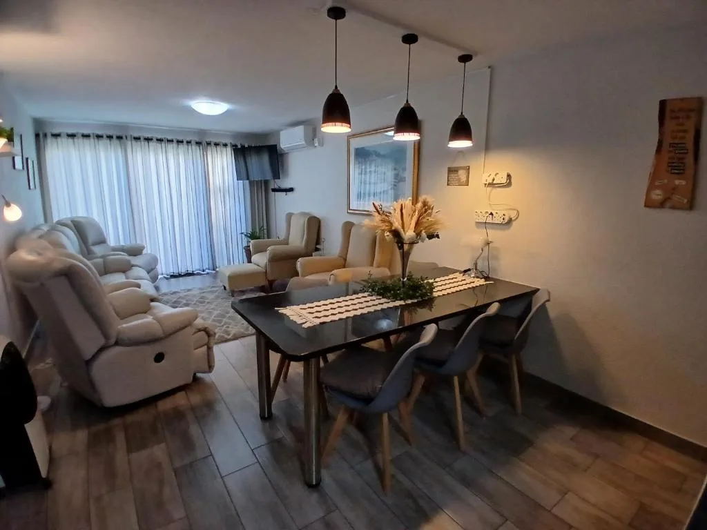 Modern dining table with black chairs and pendant lights overhead