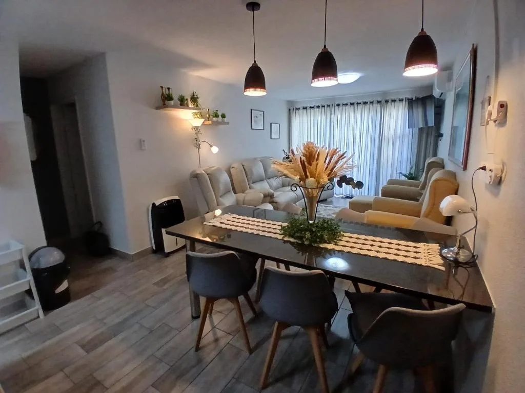 Modern dining table with black chairs and pendant lights above