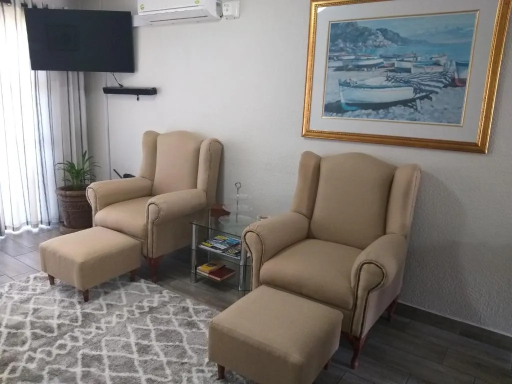 Comfortable lounge seating with beige wingback chairs and ottomans