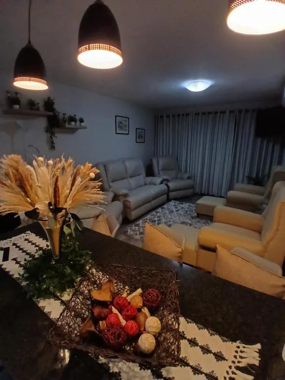Modern lounge with grey sofas, pendant lighting, and decorative flowers
