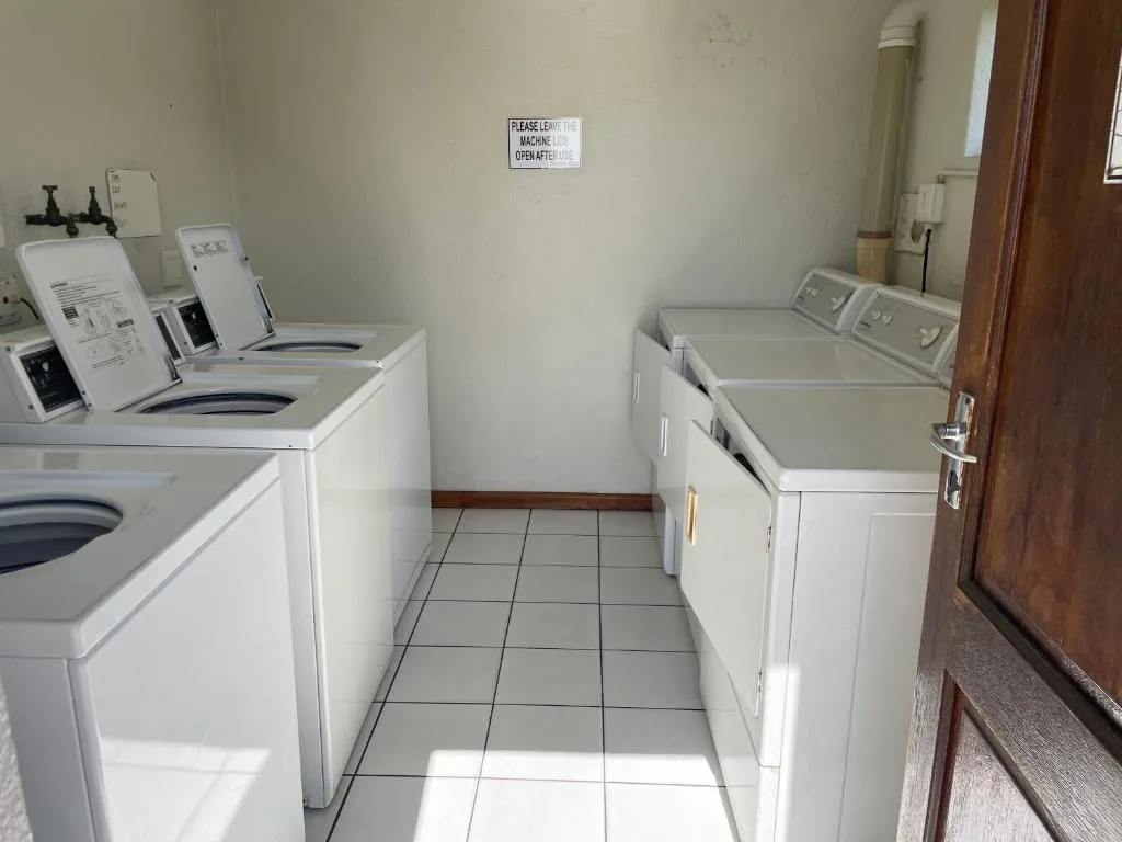 Shared laundry room with multiple washing machines and dryers