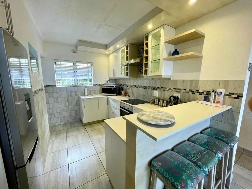 Modern kitchen with white cabinetry, island counter, and stainless steel appliances