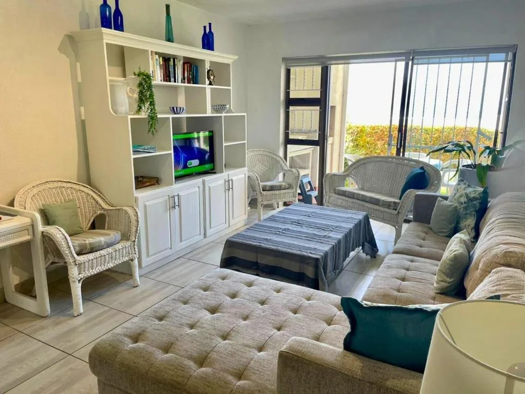 Spacious lounge with comfortable seating, white shelving unit, and scenic views