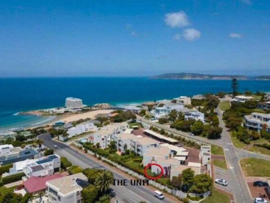 Aerial view of coastal property with ocean, beach, and islands beyond