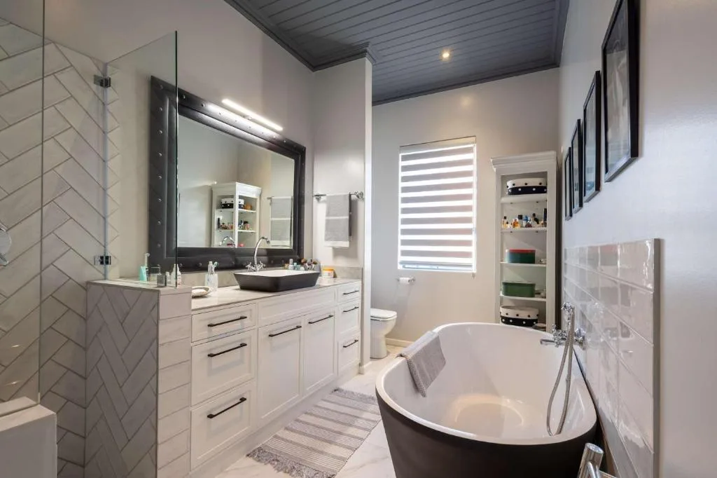 Modern bathroom with freestanding bathtub, dual vanity, and walk-in shower
