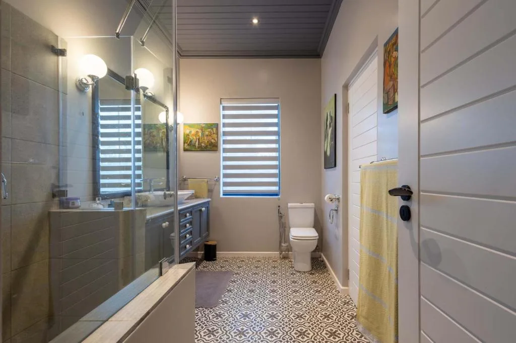 Modern bathroom with dual vanity, walk-in shower, and patterned floor tiles