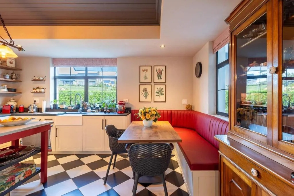 Modern dining area with red banquette seating and valley views through large windows