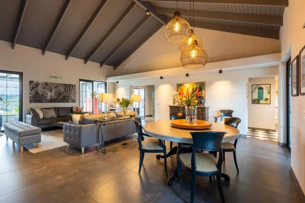 Open-plan lounge with dining table, sofa, and pendant lighting