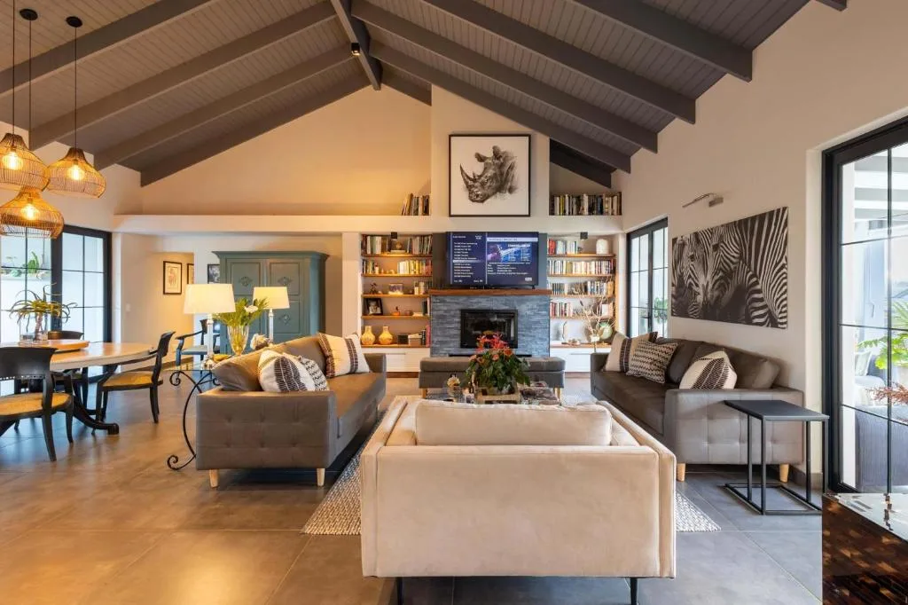 Modern living room with cream sofas, fireplace, and built-in bookshelves