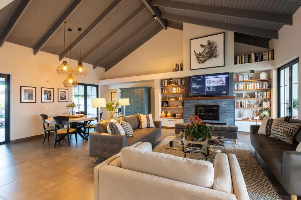 Open-plan lounge with sofas, fireplace, and built-in shelving displaying books