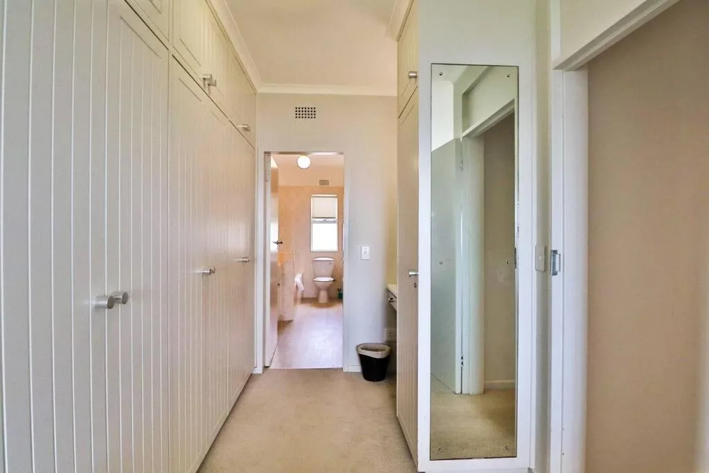 Hallway with mirrored wardrobe doors and bathroom access