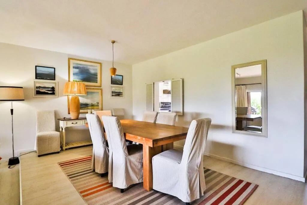 Wooden dining table with striped upholstered chairs in bright dining area