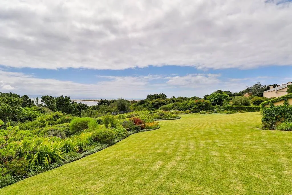 Expansive manicured lawn with lagoon and mountain vistas beyond