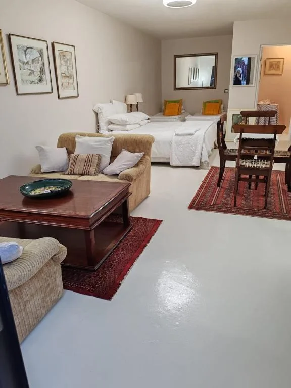 Spacious bedroom with bed, seating area, and framed wall art