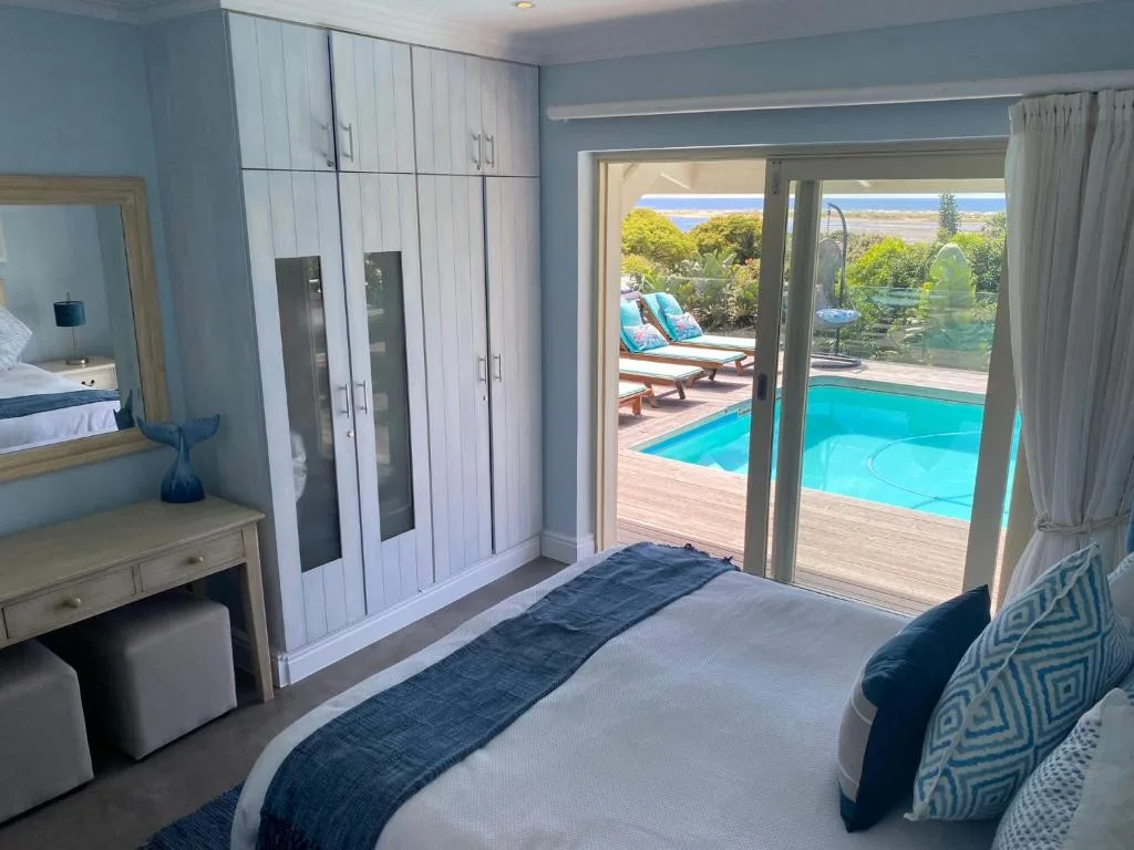 Master bedroom with pool and lagoon views through glass doors