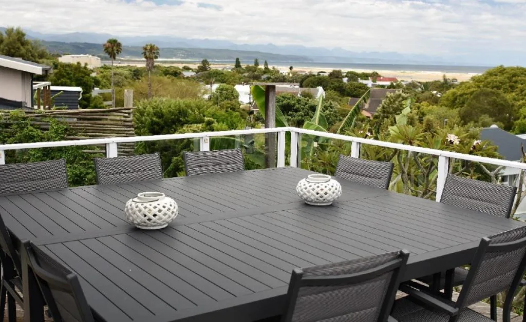 Elevated deck with dining table overlooking lagoon and mountains