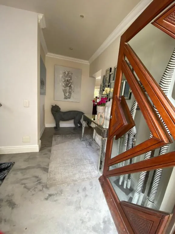Elegant hallway with wooden doors, artwork, and decorative accents